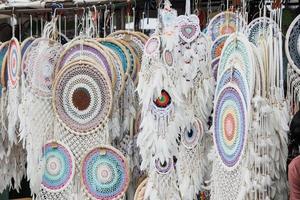 vários dreamcatchers multicoloridos brancos artesanais são vendidos no mercado. foto