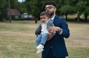 pai paquistanês asiático está segurando seu bebê de 11 meses no parque local foto