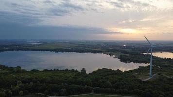 imagens de vista aérea de alto ângulo sobre a turbina eólica do moinho de vento no lago stewartby da inglaterra ao nascer do sol foto