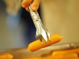 use uma longarina de aço inoxidável para espremer as salsichas. foto