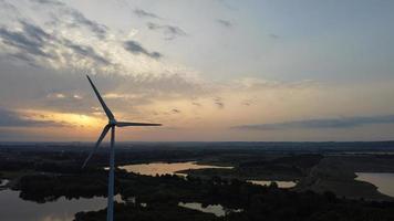 imagens de vista aérea de alto ângulo sobre a turbina eólica do moinho de vento no lago stewartby da inglaterra ao nascer do sol foto