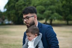 pai paquistanês asiático está segurando seu bebê de 11 meses no parque local foto