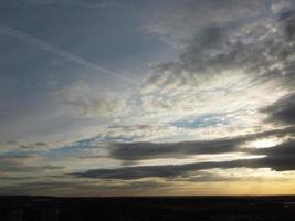 belo pôr do sol sobre a cidade britânica, céu colorido com nuvens amarelas, laranja e pretas sobre o céu azul claro foto