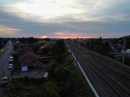 vista de alto ângulo de imagens aéreas da cidade de luton da inglaterra e estação ferroviária e trem em trilhos ao pôr do sol foto