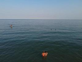 Vista de alto ângulo para o mar em frente à praia com pessoas na cidade de bournemouth, na inglaterra, reino unido, imagens aéreas do oceano britânico foto