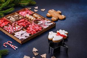 brinquedos de natal em branco e vermelho em uma caixa seccional de madeira contra um fundo escuro de concreto foto