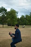 pai paquistanês asiático está segurando seu bebê de 11 meses no parque local foto