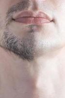 um close-up do queixo meio barbeado de um homem. conceito de barbear de homem. foto