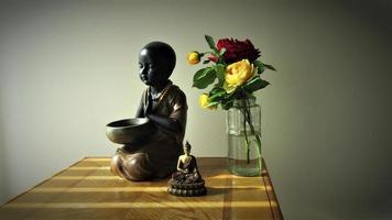 bebê monge, buda, vaso de flor rosa, meditação em casa foto