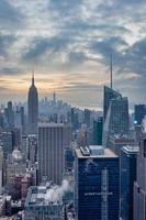 skyline de nova york do topo do deck de observação de rocha na vista do pôr do sol do centro rockefeller com nuvens no céu foto