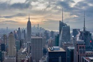 skyline de nova york do topo do deck de observação de rocha na vista do pôr do sol do centro rockefeller com nuvens no céu foto