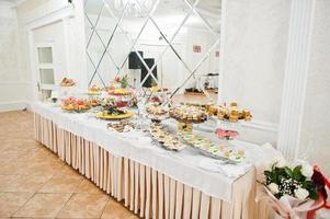 linda barra de chocolate de casamento com doces, frutas e comida. mesa de banquete de casamento foto