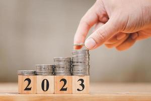ano novo 2023 com moedas empilhadas manualmente para economizar dinheiro e conceito de planejamento financeiro foto