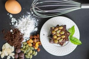 delicioso brownie de chocolate caseiro, ingredientes de brownie, closeup fudge brownie, padaria caseira e sobremesa, pedaços de brownie fresco, conceito de confeitaria. foto