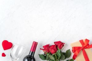 vista superior do presente de dia dos namorados com rosa e vinho, conceito de design de refeição festiva foto