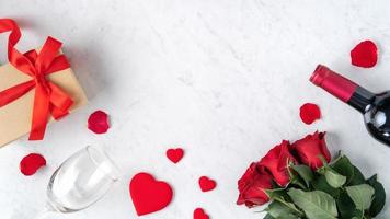 vista superior do presente de dia dos namorados com rosa e vinho, conceito de design de refeição festiva foto