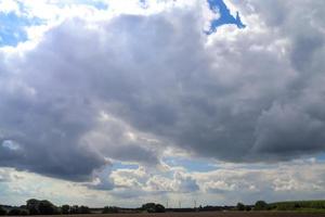 belas nuvens em um céu azul em uma paisagem agrícola do norte da Europa foto