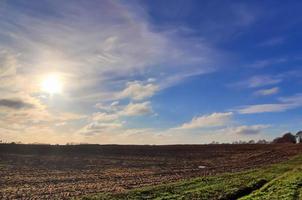 belas nuvens em um céu azul sobre um campo agrícola do norte da Europa. foto