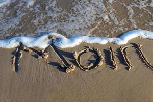 a palavra alemã ostsee mar báltico e um coração escrito na areia da praia. foto