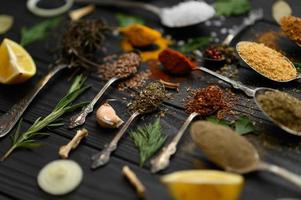 coloridas várias ervas e especiarias para cozinhar em fundo rústico de madeira escura foto