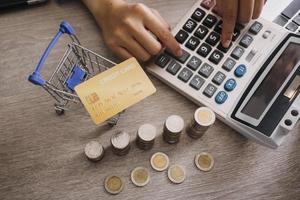 mãos segurando um cartão de crédito e usando o laptop. compras online foto