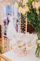 arranjo de flores para casamento de verão, feito de rosas e ramos verdes em uma mesa de jantar no restaurante. , vidro e pratos no restaurante do lado de fora em um dia ventoso com efeito de grão de filme foto