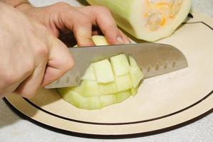 receita de bolinhos de abobrinha. passo 2 - corte abobrinha. mãos corte a abobrinha verde em cubos. foto