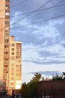 edifício amarelo na cidade à noite e céu noturno com nuvens. belo pôr do sol e uma casa na cidade. foto