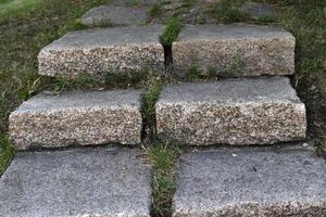 um caminho de pedra no parque e uma escada de granito com degraus. degraus de pedra no jardim. foto