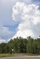 nuvens de trovoada em um dia de verão e uma estrada na zona rural. uma tempestade em um dia claro. foto