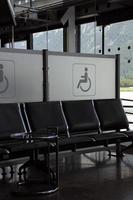 ícone de deficientes ao lado de assentos no portão do aeroporto foto