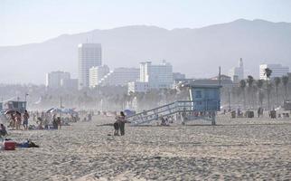 los angeles, 12 de julho de 2022 - as pessoas aproveitam o sol da tarde na praia de venice, los angeles, com colinas enevoadas ao fundo foto