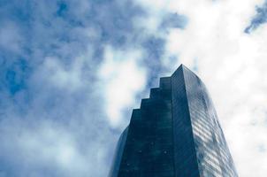 prédio alto arranha-céu com céu azul nublado