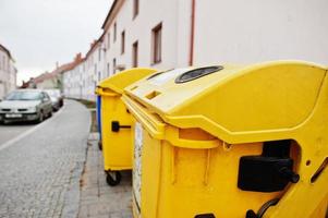 latas de lixo amarelas para plástico na rua. foto
