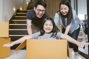 família asiática se mudando para casa nova com caixas de papelão e jogando caixa de papelão. foto