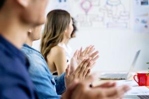 feliz negócio asiático batendo palmas após reunião de negócios bem sucedida no escritório moderno foto