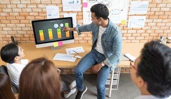 homem de negócios indiano e sua apresentação de equipe no monitor de tela por gráfico e gráfico mostram lucro e reunião no conceito de idéias de planejamento de design de escritório moderno foto