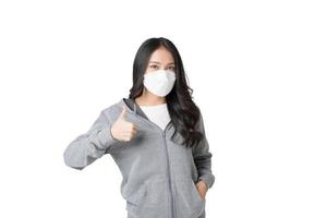 jovem mulher asiática usando máscara higiênica para prevenir infecção por vírus corona poluição do ar pm2.5 em isolado no fundo branco foto