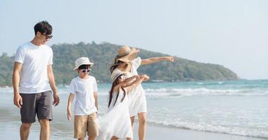 família asiática andando na praia com crianças conceito de férias felizes