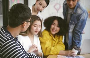 grupo de equipe de empresários criativos asiáticos jovens sérios reunidos no escritório moderno, planejando e compartilhando ideias foto