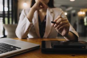 empresário e equipe analisando a tarefa de finanças do balanço financeiro. com telefone inteligente e laptop e tablet. conceito de gestão de riqueza foto