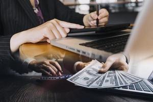 empresário e equipe analisando a tarefa de finanças do balanço financeiro. com telefone inteligente e laptop e tablet. conceito de gestão de riqueza foto