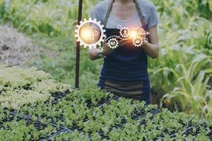 empresário futurista cultiva legumes e culturas usando tecnologia moderna de ai usando telefones celulares, sensores de temperatura e umidade, rastreamento de água, controle climático, ícones de dados de dados holográficos. foto
