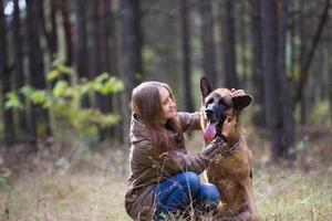 jovem mulher atraente brincando com cão pastor alemão ao ar livre no parque outono, close-up foto