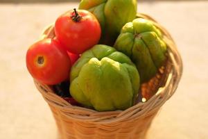 tomates frescos e abóbora em uma cesta feita de folhas de bambu. foto