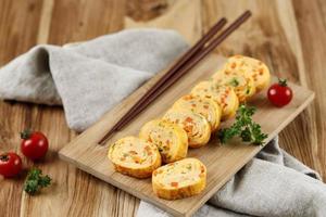 rolo de omelete de ovo coreano ou gyeran mari com cebolinha e cenoura. foto