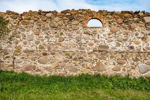 superfície de um velho muro de enormes pedras de um edifício destruído foto