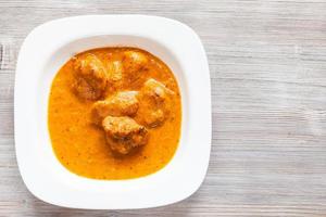 murg makhan masala pedaços de frango na mesa de madeira foto