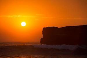 pôr do sol sobre o templo hindu pura tanah lot, bali, indonésia foto