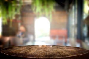 foco selecionado mesa de madeira marrom vazia e café café ou restaurante desfocar a imagem de fundo. para sua fotomontagem ou exposição de produtos foto